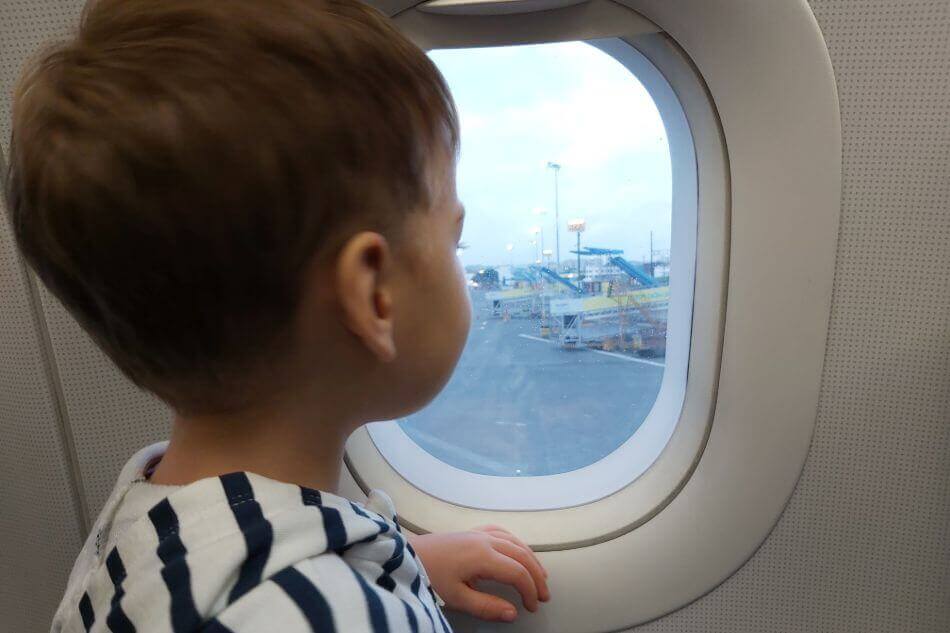 Een kind kijkt door het vliegtuigraam